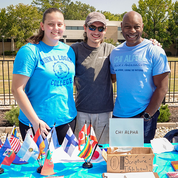 Chi Alpha club members at table during Loganpalooza event